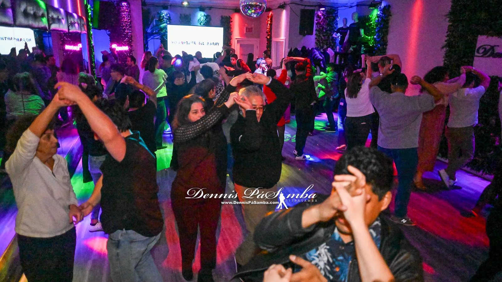 Couples in closed position dancing bachata at the studio