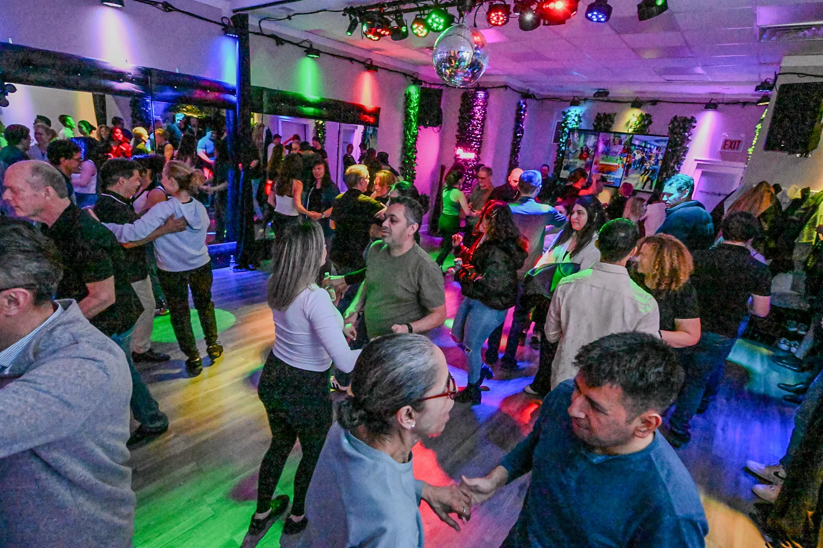 Wide view of the crowd dancing at a Latin dance social in Portage Park