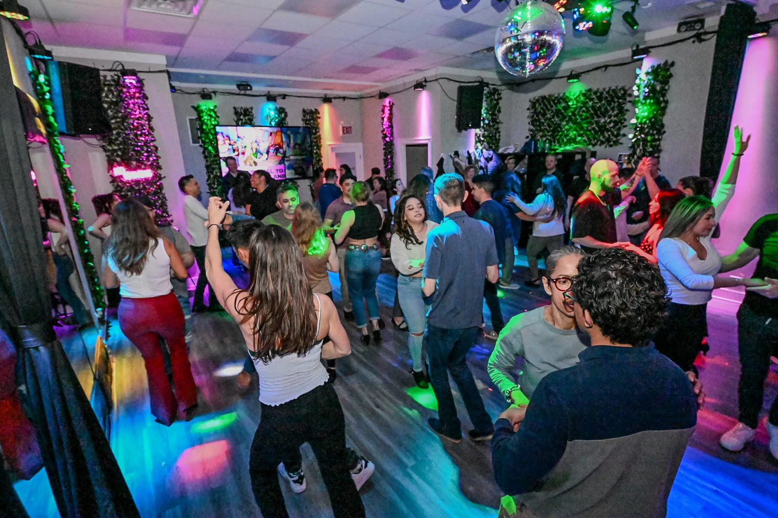 Salsa dancers spinning under stage lights at the studio social