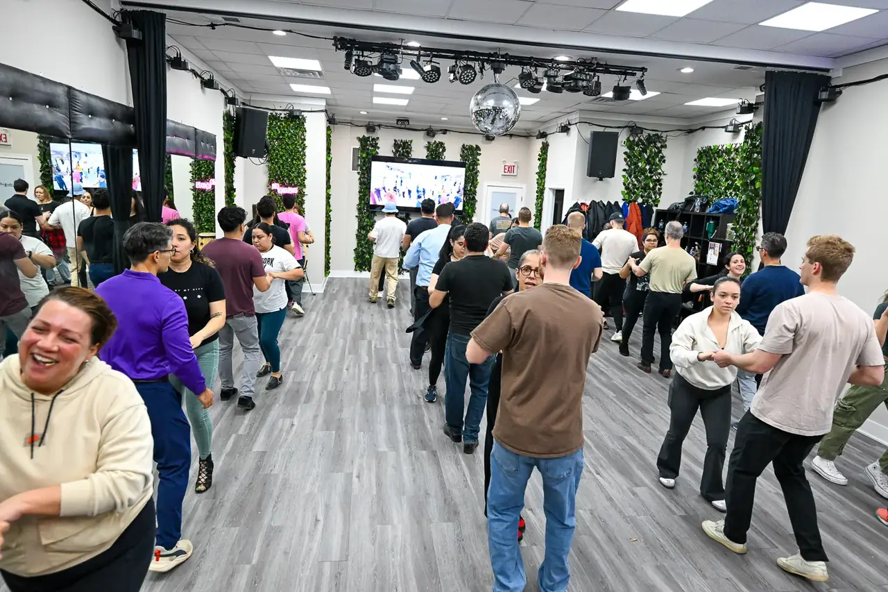 Beginner bachata class lined up on the dance floor during a lesson in Chicago