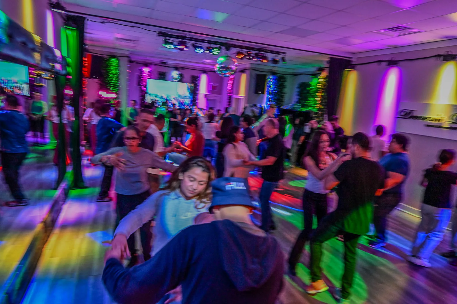 Dancers in motion under colored lights at a Friday night salsa social in Chicago