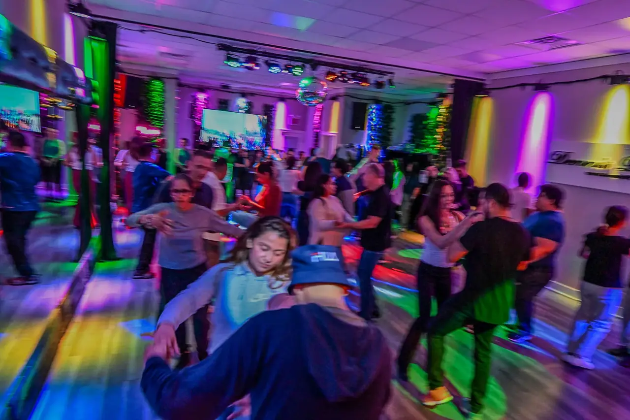 Dancers in motion under colored lights at a Friday night salsa social in Chicago